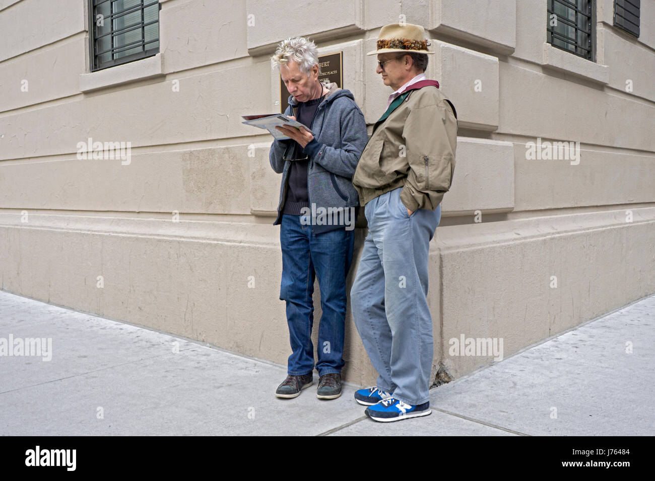 Zwei mittleren Alters männlichen Touristen Stop an einer Straßenecke eine Karte auf Studienplatz in Greenwich Village, Manhattan, New York City zu lesen. Stockfoto