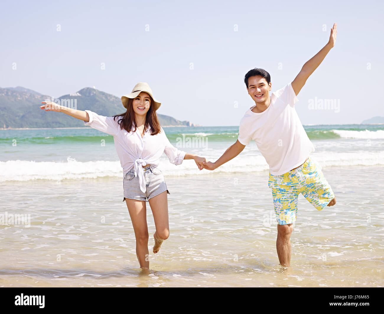 junge asiatische Brautpaar Spaß am Strand. Stockfoto