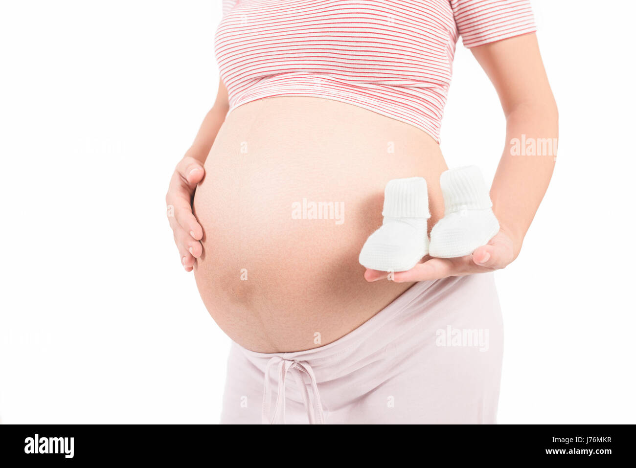 Bauch einer schwangeren und Neugeborenen Schuhe Stockfoto
