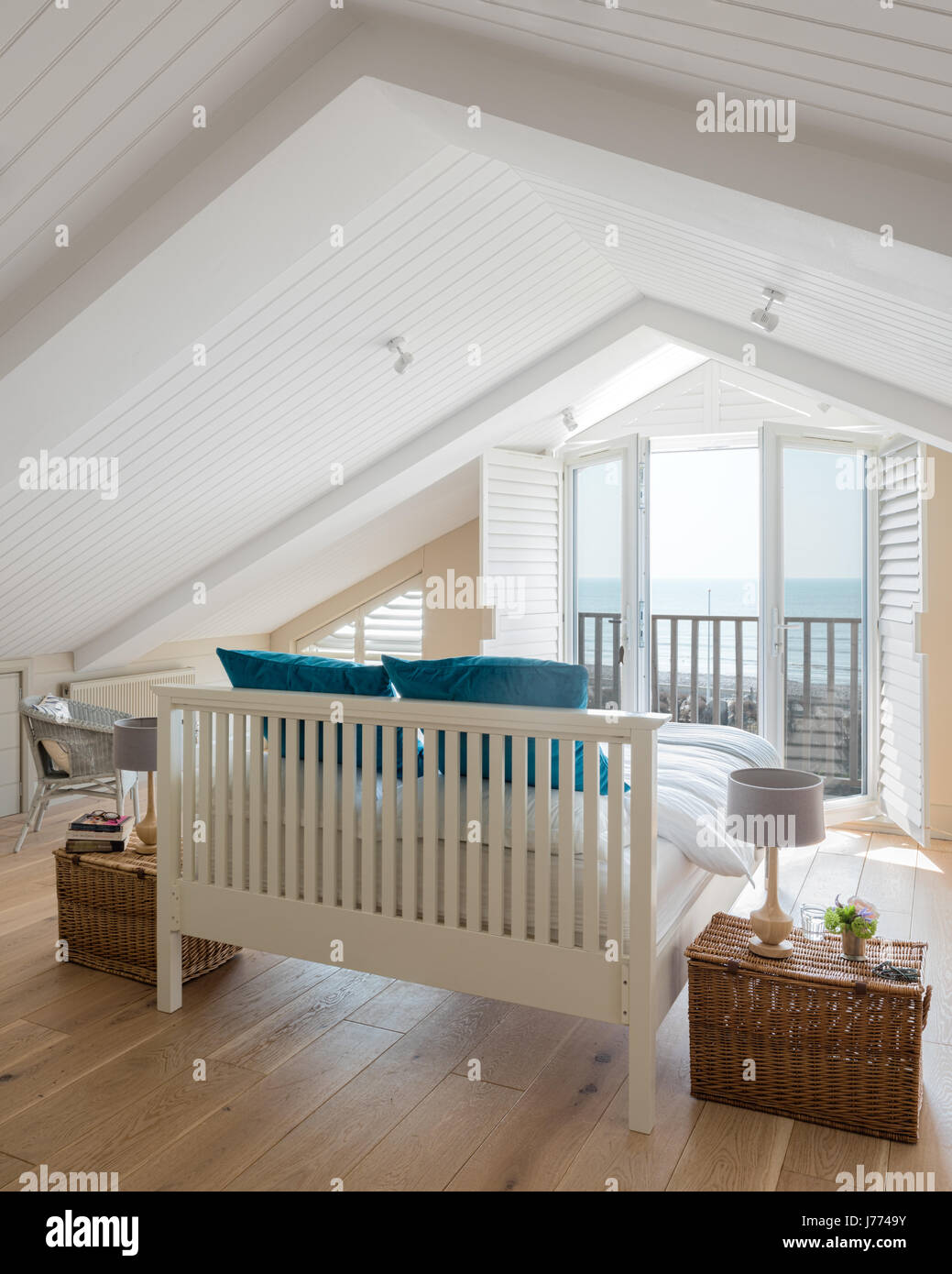 Feder & schwarz Bett im Obergeschoss Schlafzimmer mit schrillen Decke, Balkon und Fensterläden. Geschenkkörbe von Fortnum & Mason wurden als Nachttisch Registerkarte verwendet Stockfoto