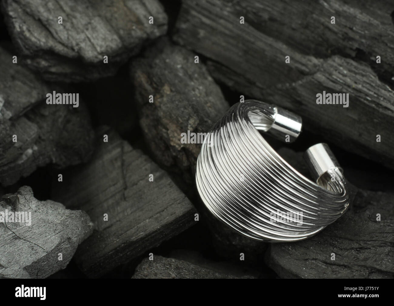 Silber Schmuck Ring auf Steinkohle-Hintergrund Stockfoto