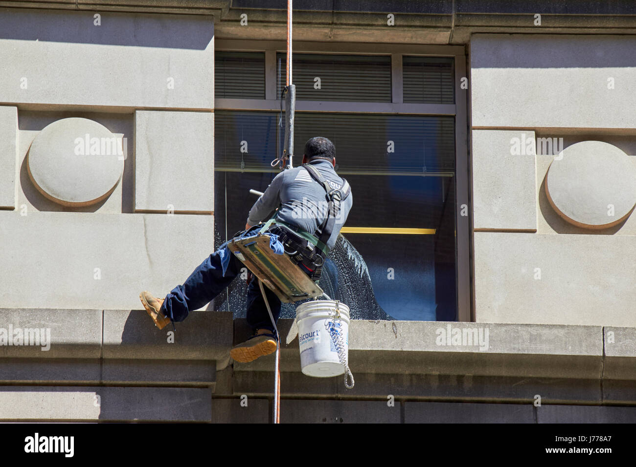Mann Reinigung Windows mit Abseilen Seil Techniken Washington DC USA Stockfoto
