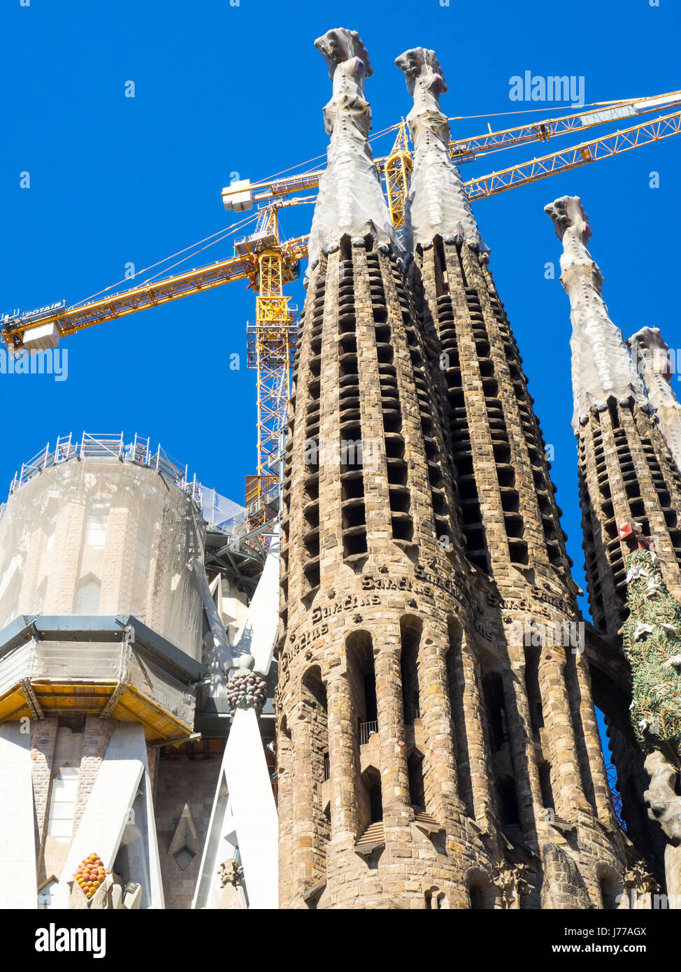 Aufwendig gestalteten Turmspitzen und Baukräne von Gaudis Sagrada Familia Basilika, Barcelona, Spanien. Stockfoto