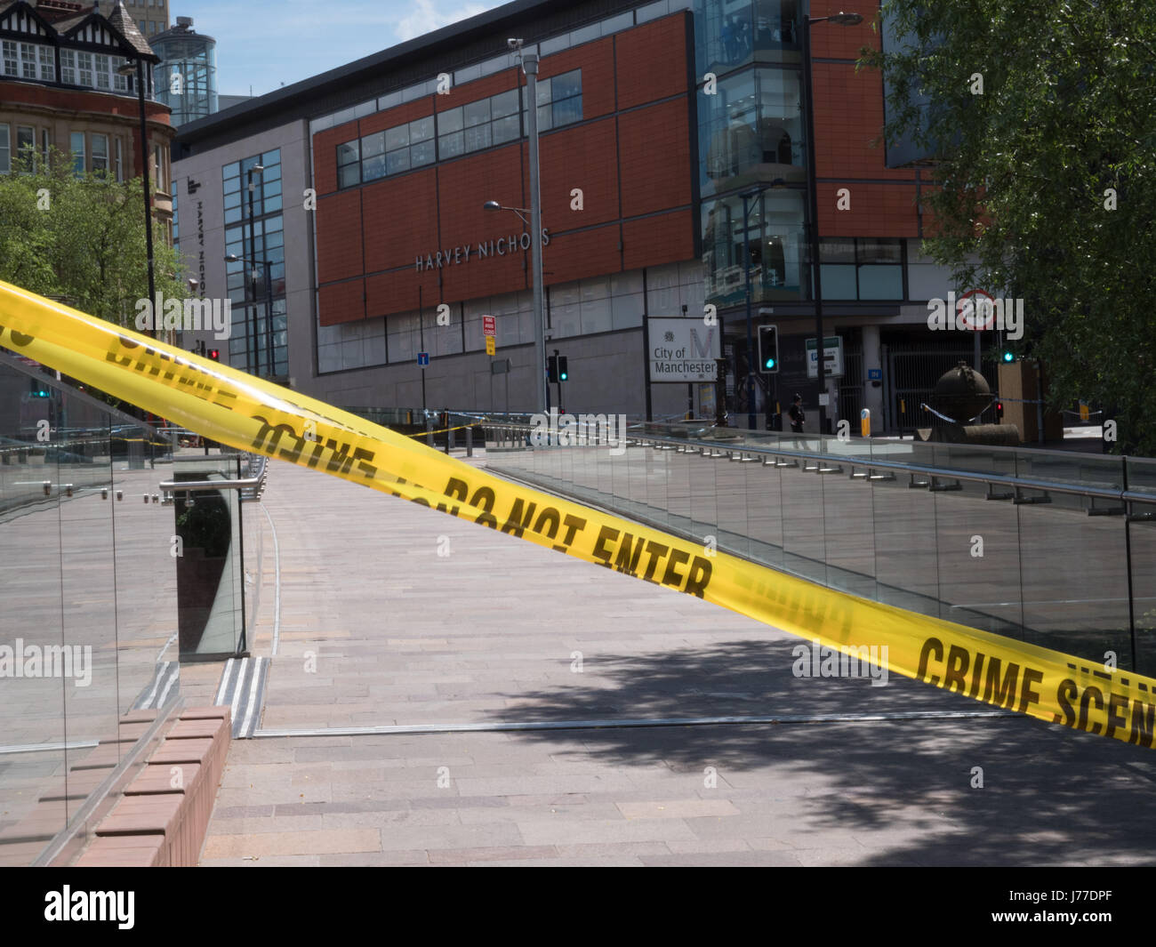 Manchester, UK. 23. Mai 2017. Die Polizei Kriminalität Szene Klebeband verwendet als einen Kordon in der Nähe der Manchester Arena in Manchester Stadtzentrum (mit Harvey Nichols Store und City of Manchester Zeichen sichtbar), am Tag nach ein Selbstmordanschlag 22 ums Leben, als Massen der Ariana Grande-Konzert in der Arena Manchester gingen. Bildnachweis: Chris Rogers/Alamy Live-Nachrichten Stockfoto