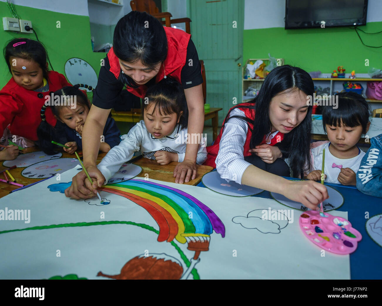 (170524)--YUYAO, 24. Mai 2017 (Xinhua)--Kinder malen Bilder von ihrer Heimatstadt unter Anleitung der Freiwilligen während einer Aktivität, die kommende Drachenboot-Festival in Yuyao, Ost-China Zhejiang Provinz, 24. Mai 2017 zu begrüßen. Freiwillige und einige 60 Kinder von Wanderarbeitnehmern besuchten die Aktivität in einem Kindergarten am Mittwoch. (Xinhua/Xu Yu) (Mcg) Stockfoto