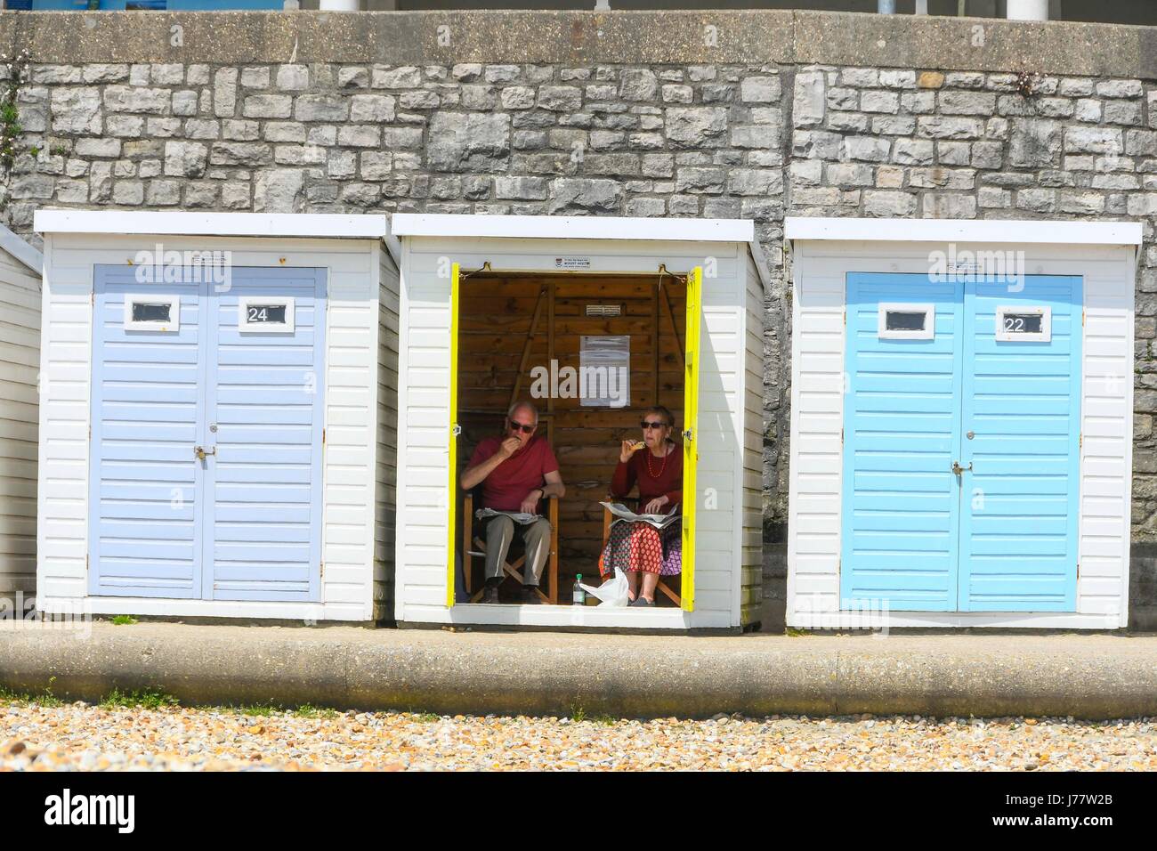 Lyme Regis, Dorset, UK. 24. Mai 2017.   Großbritannien Wetter.   Ein paar in ihre Strandhütte im Badeort Lyme Regis in Dorset, Beschattung selbst von der heißen Sonne.  Bildnachweis: Graham Hunt/Alamy Live-Nachrichten Stockfoto