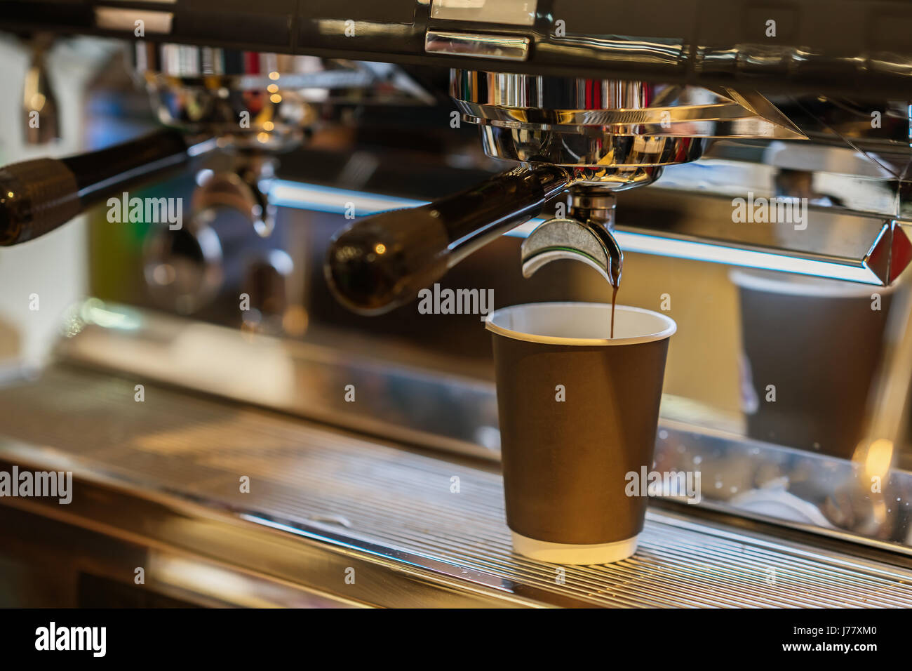 Close-up frischer Espresso gießt in Papierschale, italienische Espresso-Maschine. Kaffeekultur und professionelle Kaffeemaschine, Service, catering-Konzepte Stockfoto