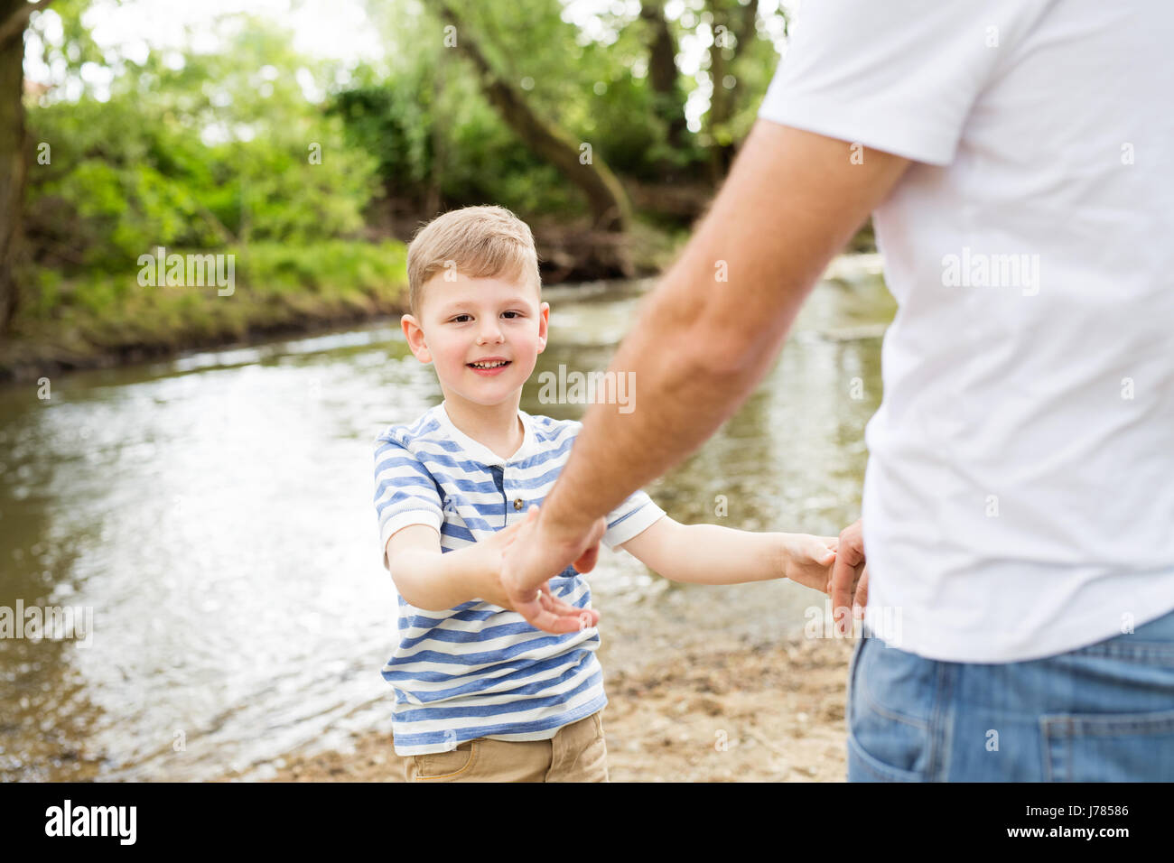 Kleiner Junge mit seinem Vater am Fluss, sonnigen Tag. Stockfoto
