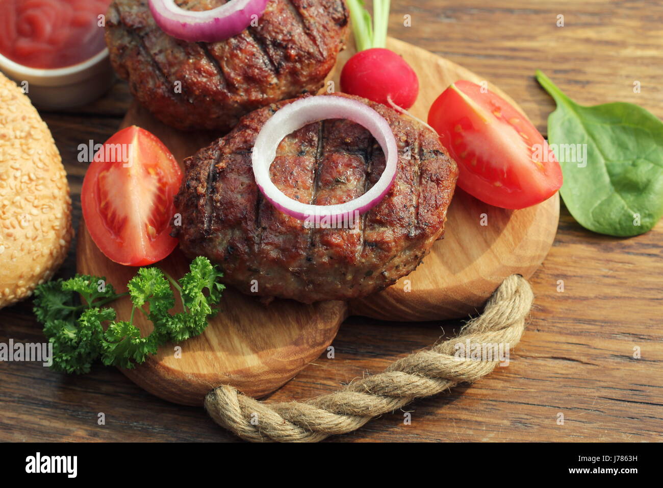 Hausgemachte Rindfleisch-Burger mit Zwiebeln auf Schneidebrett Stockfoto