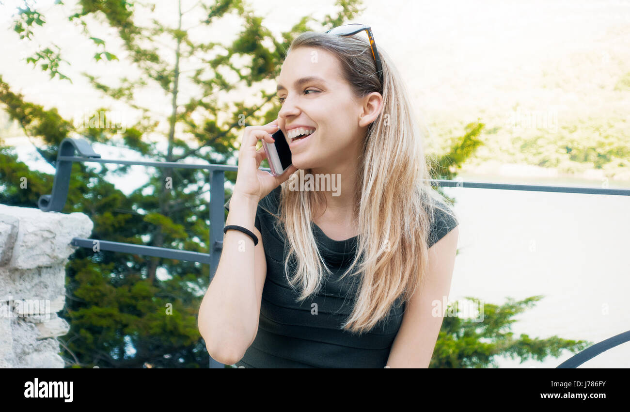 Frau mit Telefon, spricht und Lächeln Stockfoto