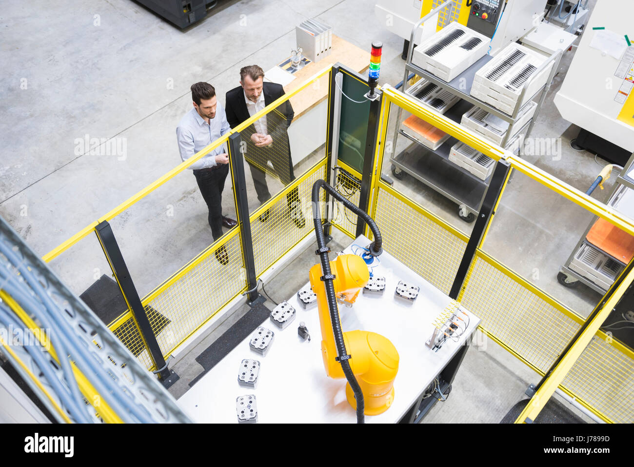 Zwei Unternehmer Beobachtung Industrieroboter in Fabrik Stockfoto