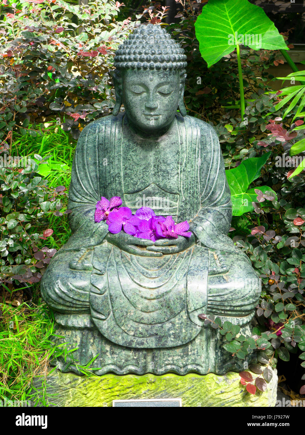 Eine heitere Bronzeskulptur des Gautama Buddha sitzt in einer meditativen Pose, die Frieden, Erleuchtung und die traditionelle Ästhetik des buddhistischen A repräsentiert Stockfoto