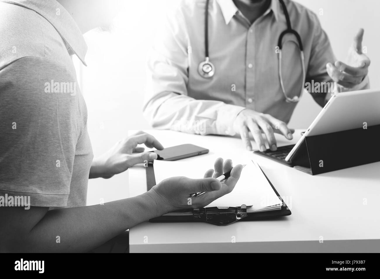 Doktor der Medizin mit Handy und consulting Geschäftsmann Patienten mit Examen als Krankenhaus Professionalität Konzept, schwarz / weiß Stockfoto