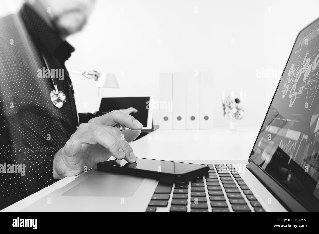 Medizintechnik-Konzept. Arzt-Hand arbeiten mit modernen digitalen Tablet Dock-Screen-Computer im modernen Büro Klinikraum, schwarz, Smartphone, laptop Stockfoto