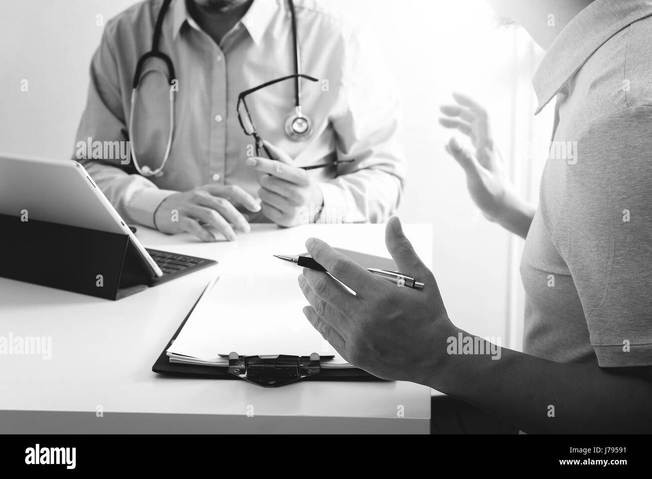 Doktor der Medizin mit Handy und consulting Geschäftsmann Patienten mit Examen als Krankenhaus Professionalität Konzept, schwarz / weiß Stockfoto