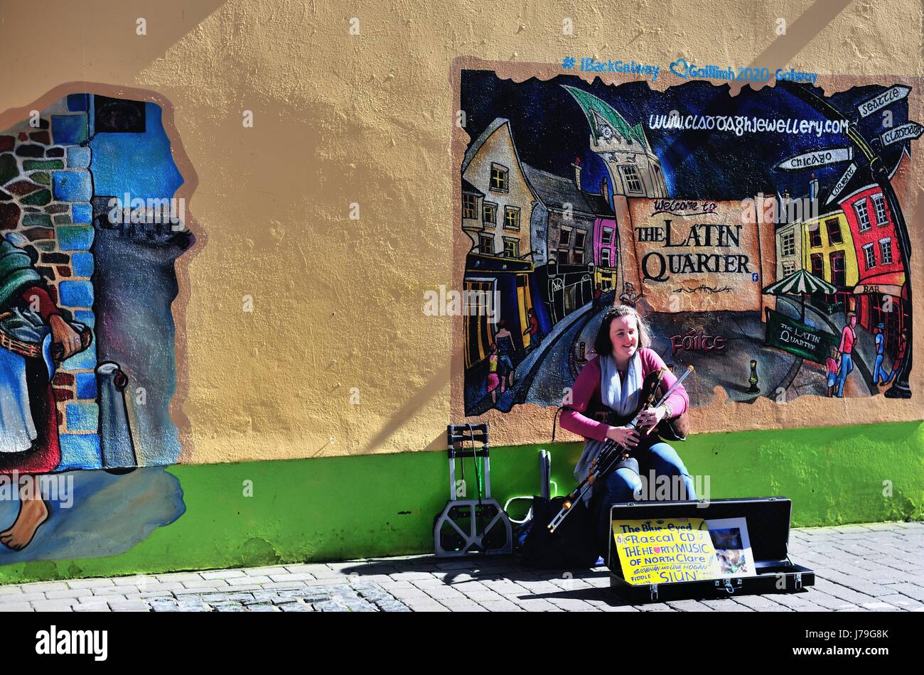 Straßenmusiker spielen traditionelle irische Musik vor einem Wandbild auf ein Geschäft im lateinischen Viertel Abschnitt von Galway, County Galway, Irland Stockfoto