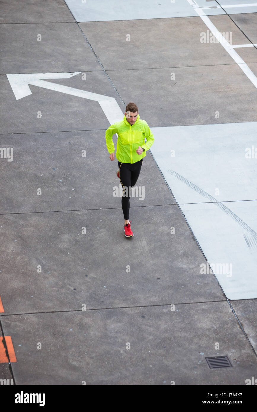 Junger Mann läuft auf Parkdeck Stockfoto