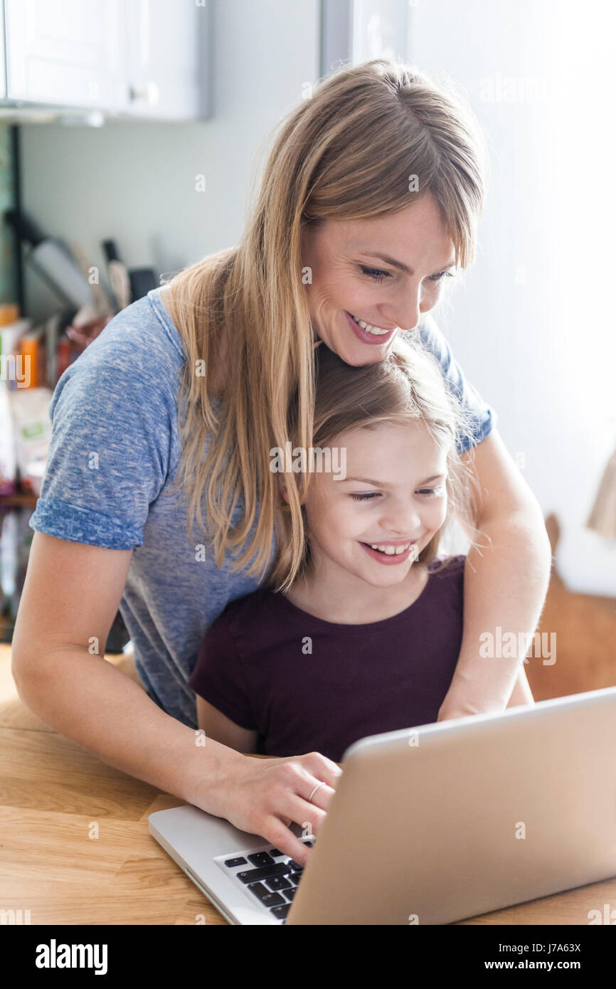 Mutter und Tochter mit Laptop in der Küche Stockfoto