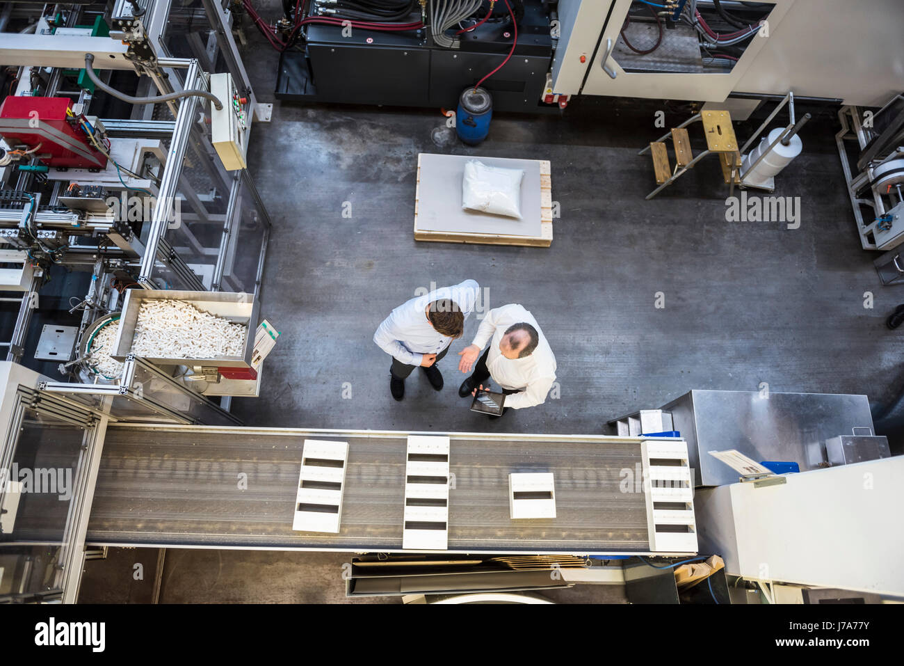 Draufsicht von zwei Männern mit Tablet sprechen in Fabrik Zeiterfassung/BDE Stockfoto