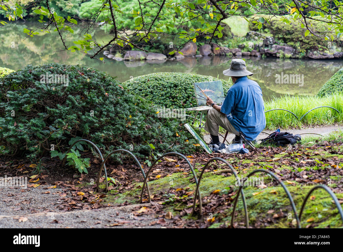 Ein Mensch malt in der ruhigen und wunderschönen Shinjuku Gyōen Park. Stockfoto