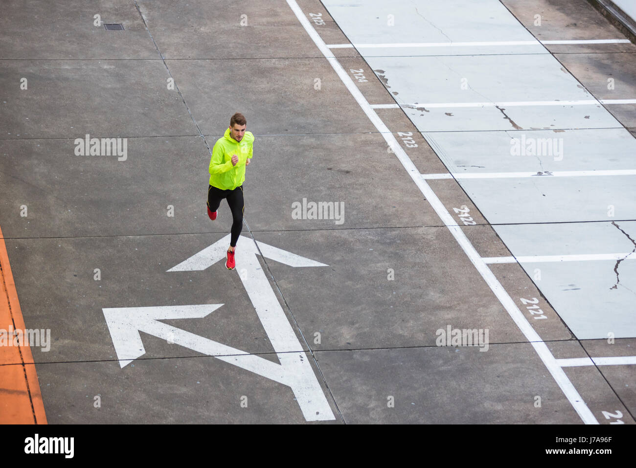 Junger Mann läuft auf Parkdeck Stockfoto