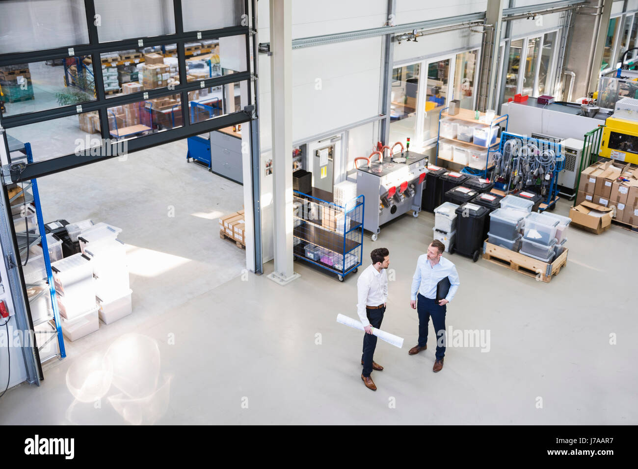 Zwei Geschäftsleute sprechen in Fabrik Zeiterfassung/BDE Stockfoto