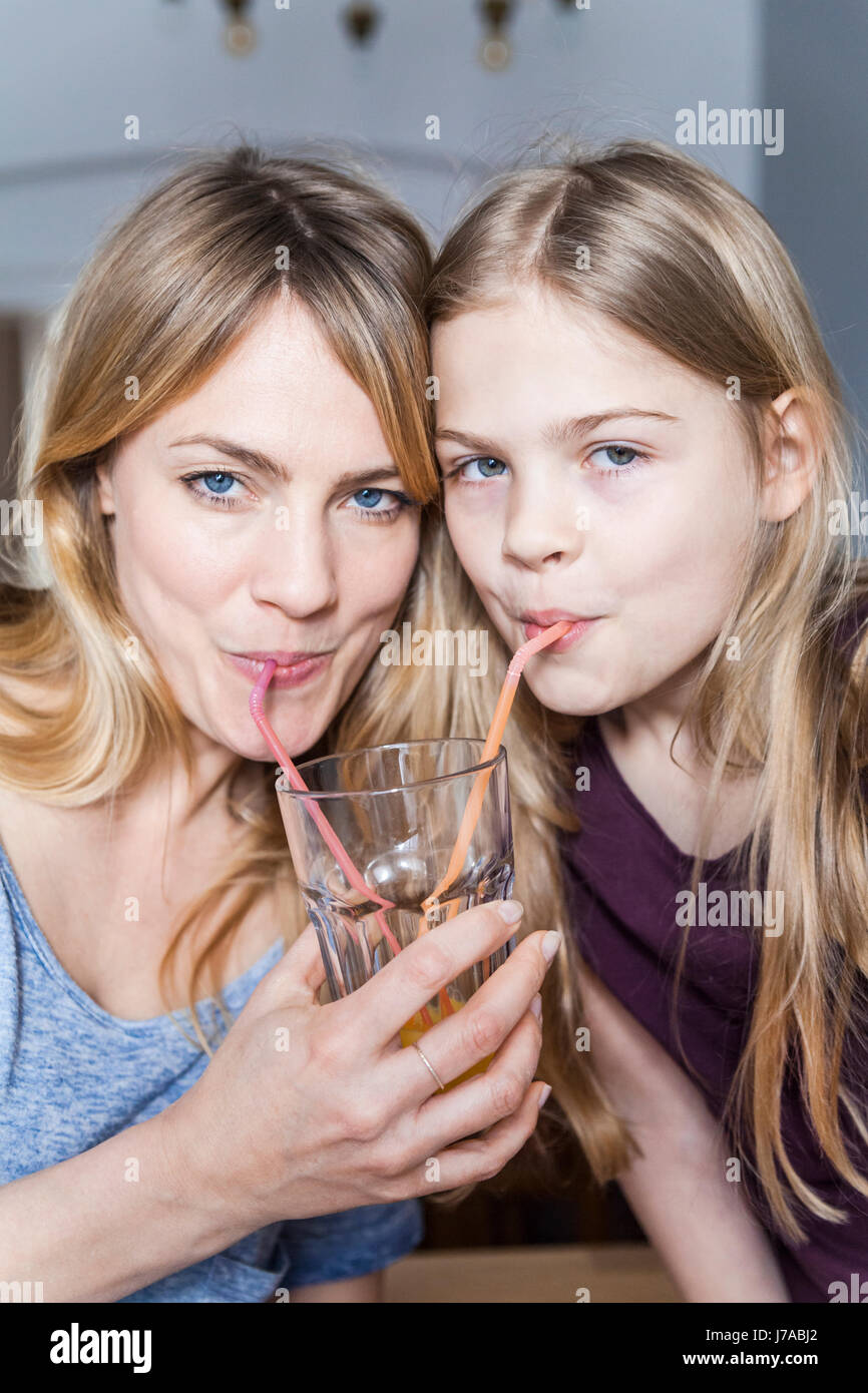 Mutter und Tochter teilen Orangensaft Stockfoto