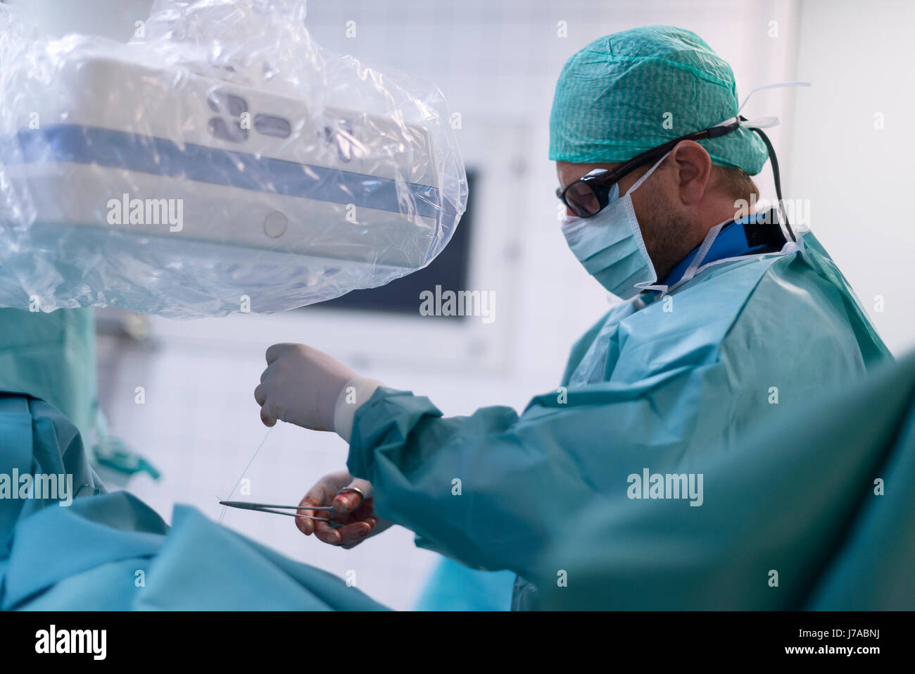 Interventionelle Radiologen Einstellung Naht zur Befestigung von dauerhaften Katheter Stockfoto