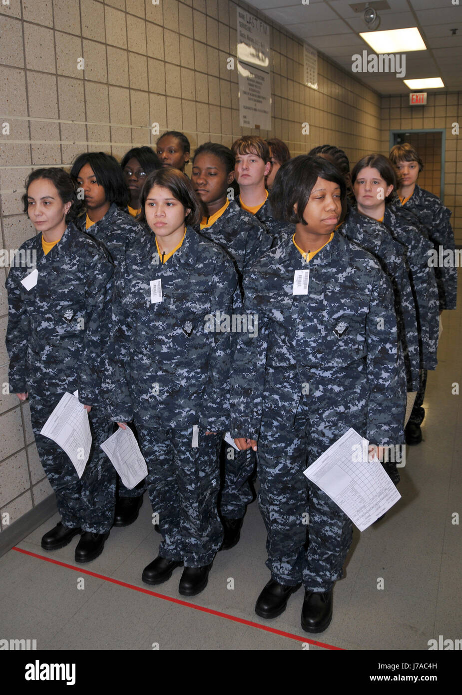 Weibliche Rekruten warten, um ihre neu ausgegebenen Marine Arbeitsuniform untersucht haben. Stockfoto