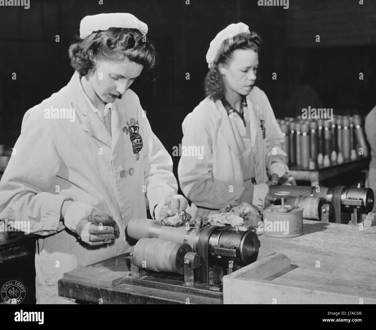 Frauen sind überschüssige Farbe aus den Bands dieser Kreis Munition Muscheln, 1943 entfernen. Stockfoto