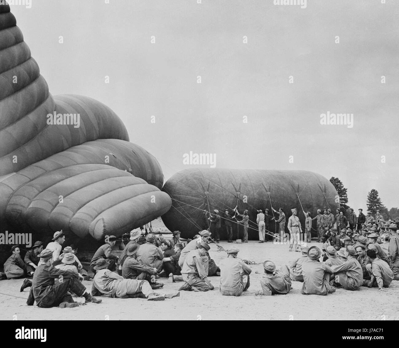 Auszubildenden beobachten Instruktor auf einen Sperrfeuer Ballon aufblasen, während des zweiten Weltkriegs. Stockfoto