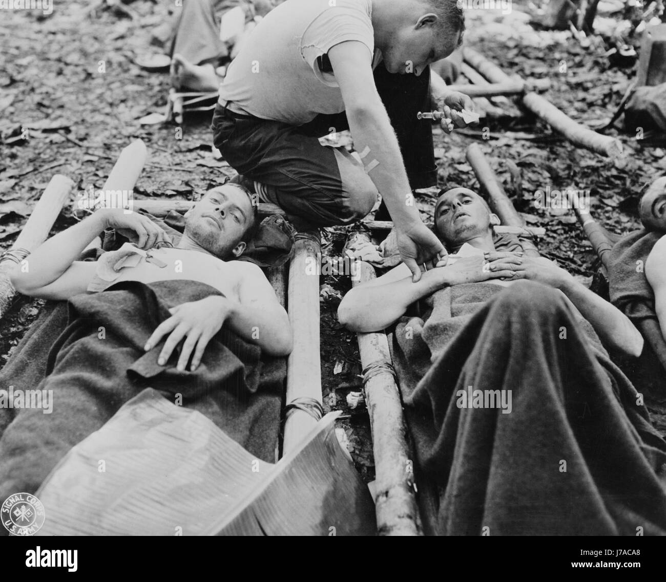 Vertrauensarzt mit Aufmerksamkeit für verwundete amerikanische Soldaten in Neu-Guinea, ca. 1942-1945. Stockfoto