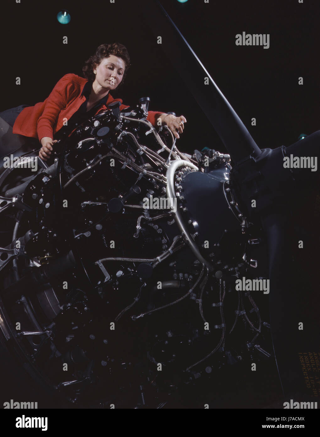 Frau arbeitet an einem großen Motor im Werk Douglas Aircraft Company, 1942. Stockfoto