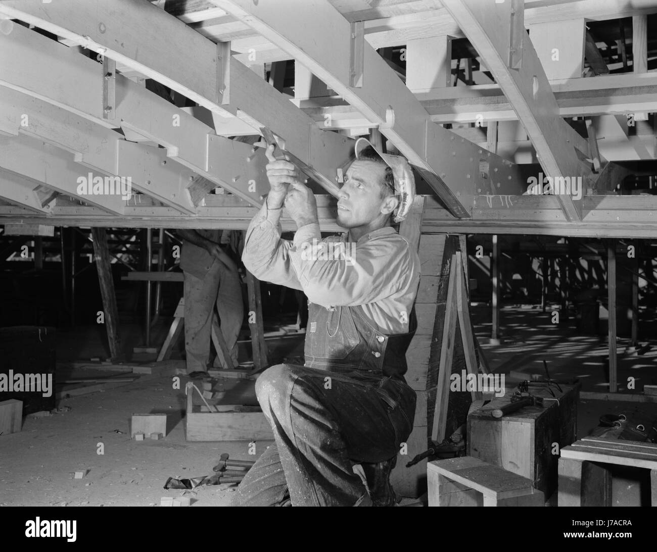 Mann, der arbeitet mit einem Meißel an einem Träger eines Motorbootes Torpedo für die Marine, 1942. Stockfoto