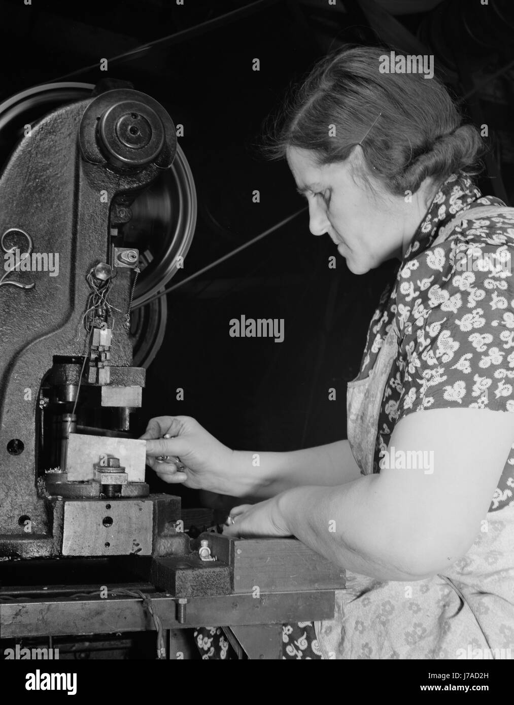 Arbeitnehmerin Stanzen von Löchern in elektrischen Anschlüssen mit einem Power Press, 1942. Stockfoto