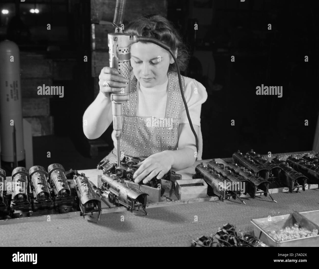 Arbeitnehmerin eine elektrische Schraubendreher zusammenzubauen Spielzeugeisenbahnen, 1942. Stockfoto