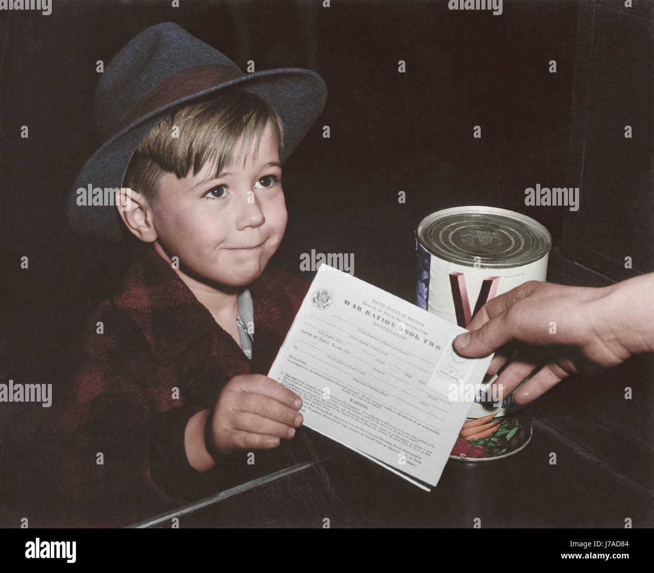 Eine eifrige Schuljunge bekommt seine ersten Erfahrungen im Umgang mit Krieg Ration Buch zwei. ca. 1943 Stockfoto