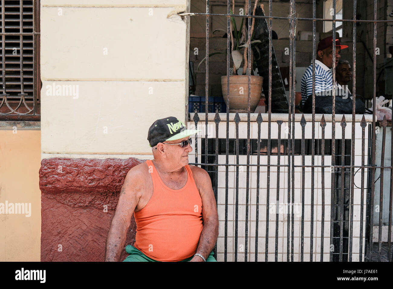 Alten kubanischen Mann sitzt auf den Straßen von Havanna mit einem Baseball-Cap von New York Stockfoto