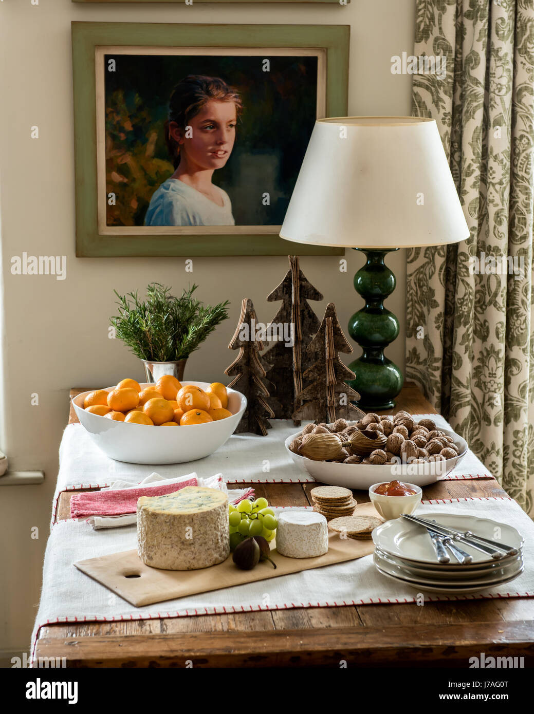 Käse vom Brett, Nüssen und Mandarinen auf einem Holztisch mit dekorativen Weihnachtsbaum Modelle Stockfoto