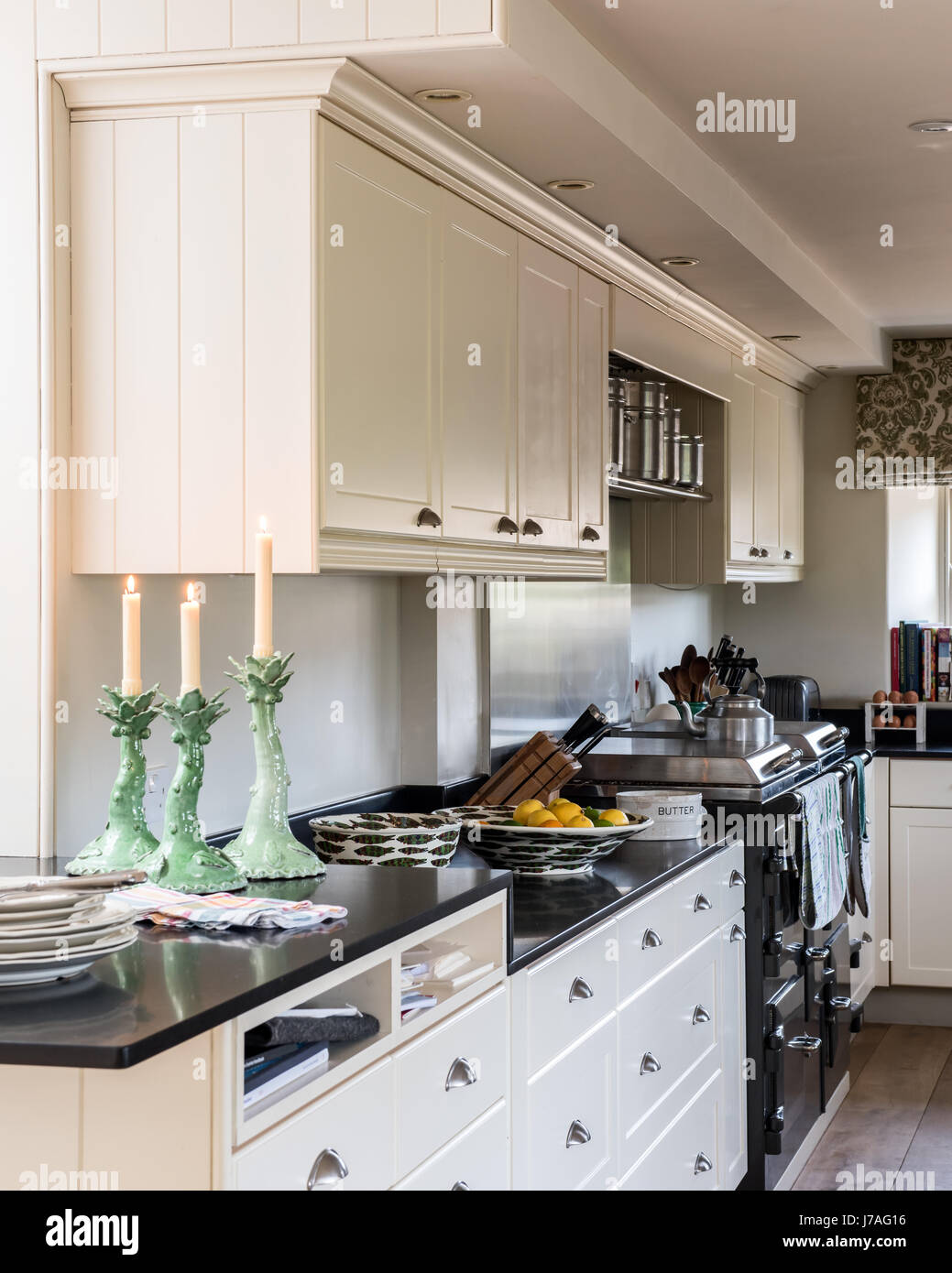 Elegante wollweiße Küche mit schwarzen Stein Arbeitsplatten. Stockfoto