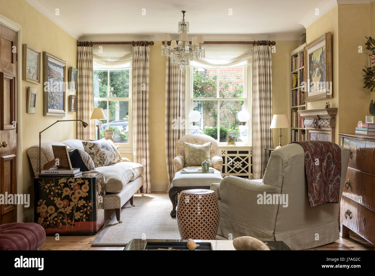 Traditionellen englischen Stil Wohnzimmer mit Howard Stil Sessel, Lack Brust von Colefax & Fowler und antiken Kronleuchter. Stockfoto
