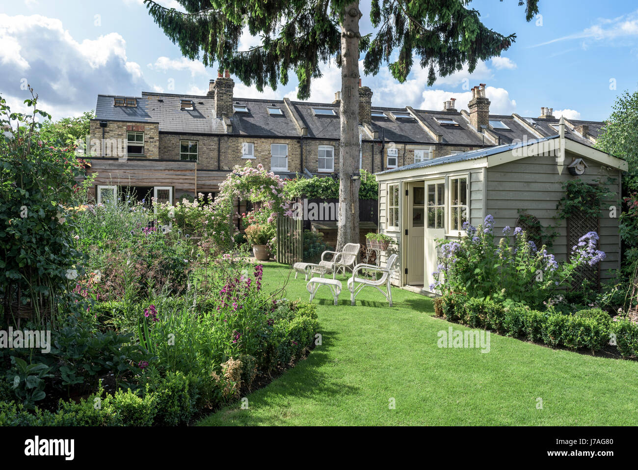 Sommerhaus in englischer Garten mit Korbweide Möbel und ordentlich Rasen Stockfoto