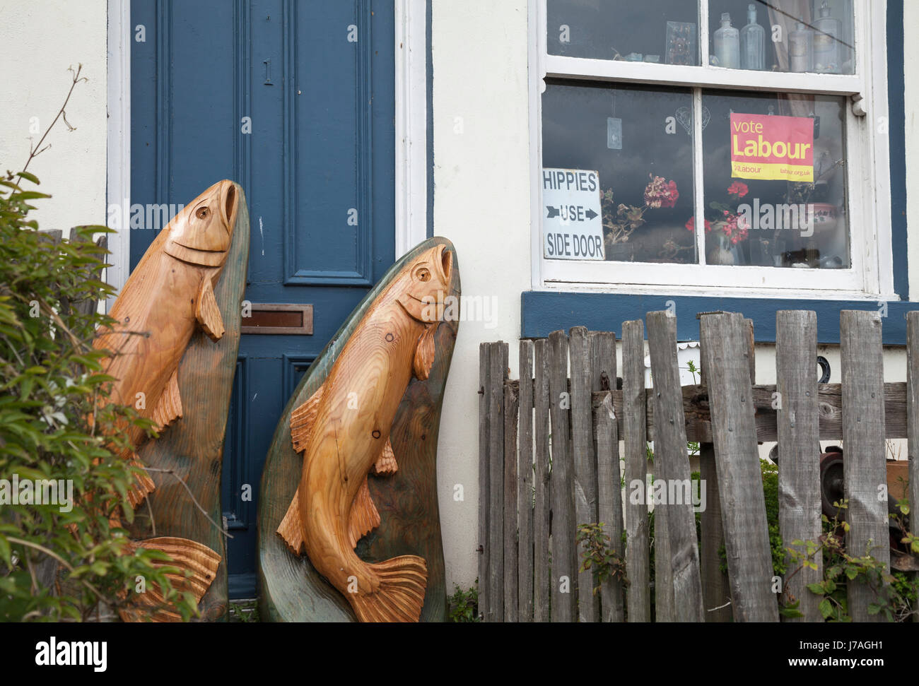 Zwei hölzerne Fische auf ein Tor vor einem Haus in Staithes, North Yorkshire, England, UK Stockfoto