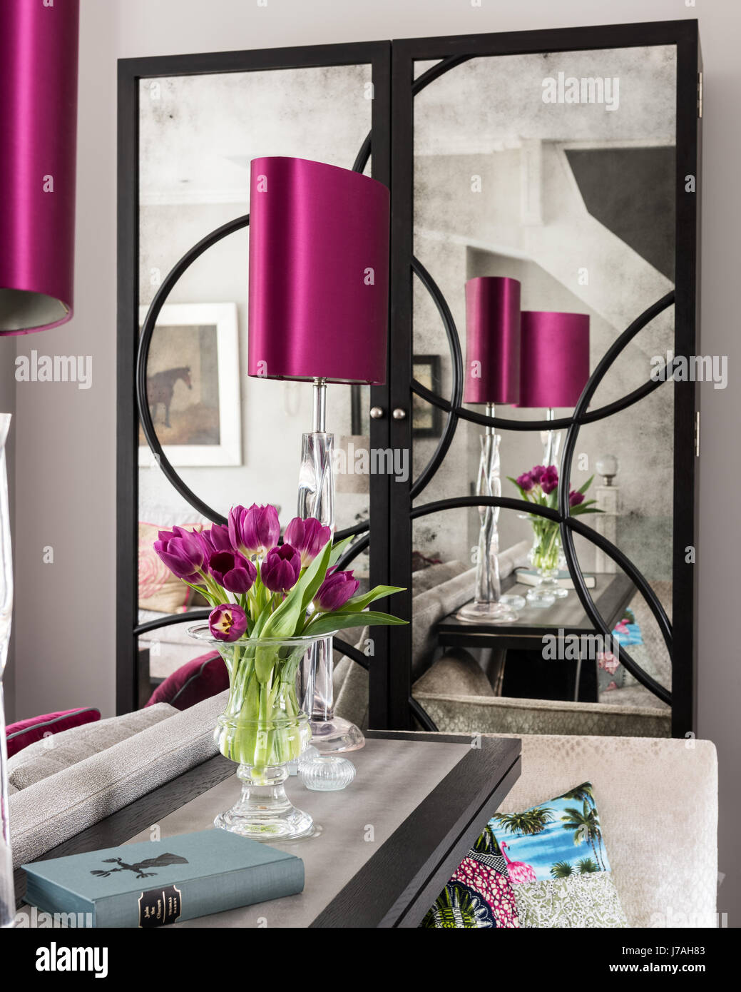 Rosa Lampenschirm und Tulpen auf Harome Konsole spiegelt sich in Spiegelschrank in Victorian Terrace, London Stockfoto