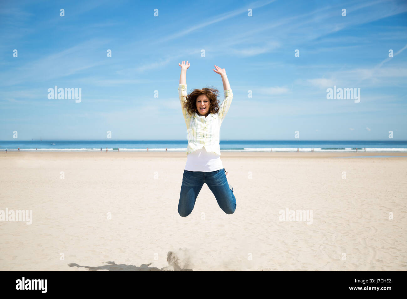 Froh, dass Mitte springen am Strand verrückt nach Urlaub im Alter von Stockfoto