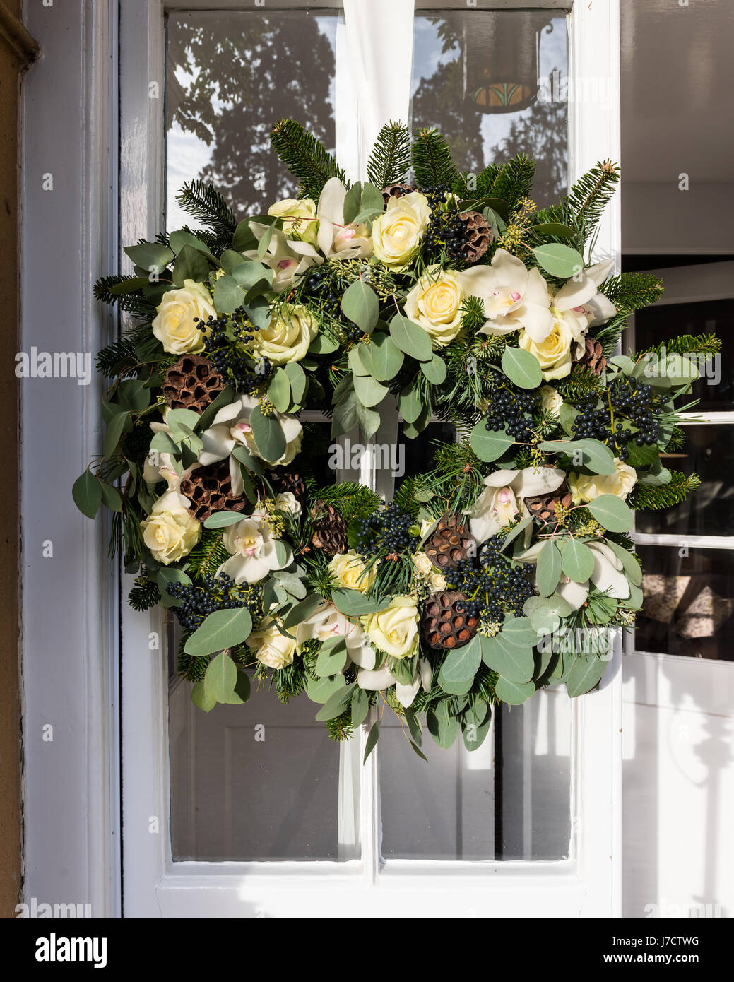 Eine schöne handgemachte Kranz aus verdrehten Weide, weißen Rosen und Lotusblumen an Eingangstür Stockfoto
