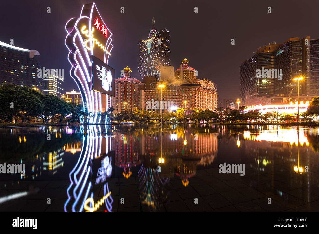 Macao, CHINA - 23. April 2017: Die Lichter von einem berühmten Casino-Betreiber Wynn reflektieren auf dem Wasser mit dem Lisboa Casino-Turm im Hintergrund. Macau rece Stockfoto