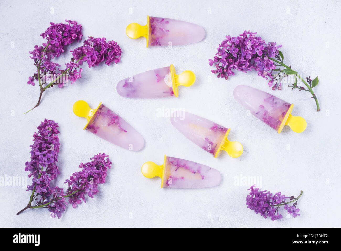 Eis am Stiel mit lila Blumen Stockfoto