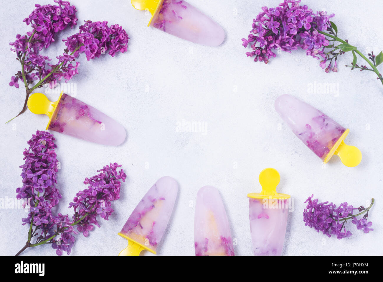 Eis am Stiel mit lila Blumen Stockfoto
