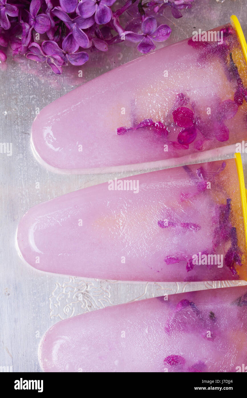 Eis am Stiel mit lila Blumen Stockfoto
